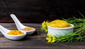 mustard sauce with its ingredients, turmeric, seeds and flowers