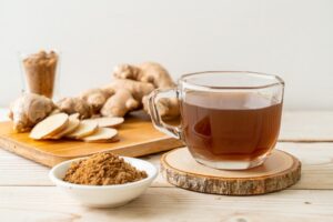 hot and sweet ginger juice glass with ginger roots - Healthy drink style